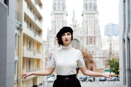 Retro styled portrait. Parisian woman in old fashioned classic outfit at the entrance to the gothic castle.の写真素材