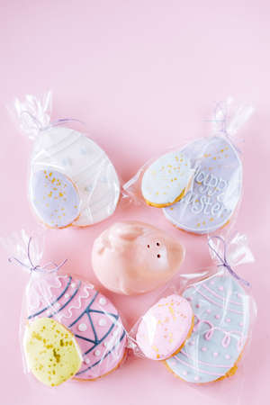 Easter holiday decoration gift basket.  Egg shaped cookies with frosting wrapped in transparent wrap...