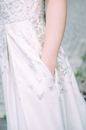 Young caucasian woman holding hand in the pocket of her wedding dressの写真素材