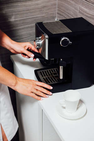 Nurse in cosmetic beauty parlour making coffee in her tiny kitchen