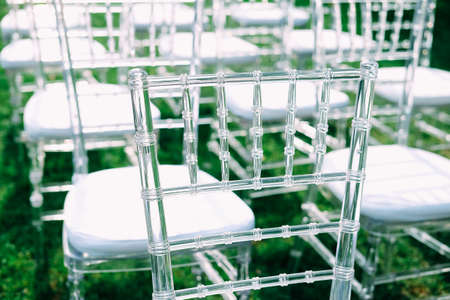 Outdoor wedding ceremony. Reception area with transparent chairs for guests.の写真素材