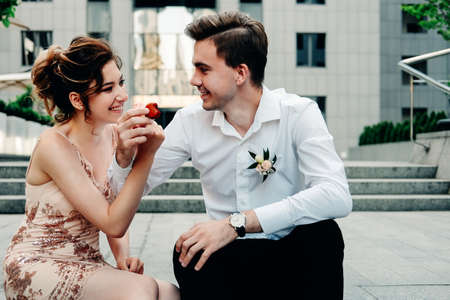 Dating concept. Young happy couple of lovers having fun and giving each other treatsの写真素材