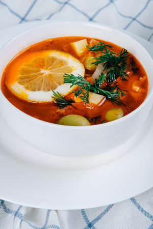 Solyanka a thick vinegary soup of vegetables and beef meat served with lemon and olives