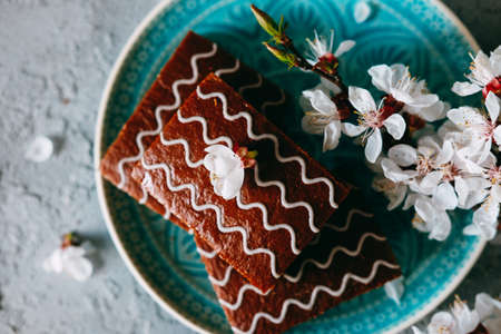 Sweet sunday dessert. Chocolate brownies with black tea on table decorated with flowers and candles.