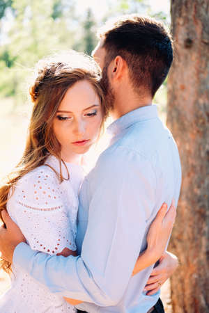 Happy couple of young lovers embracing and kissing outdoor in the summerの写真素材