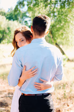 Happy couple of young lovers embracing and kissing outdoor in the summerの写真素材
