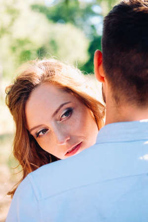 Happy couple of young lovers embracing and kissing outdoor in the summerの写真素材