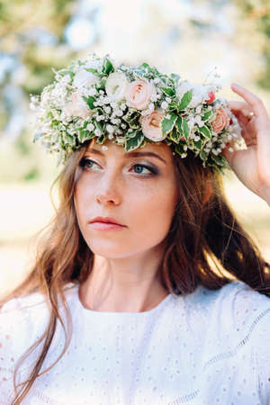 Tender young caucasian woman wearing white wreath. Wedding guest.の写真素材