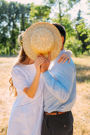Couple of young adult lovers kissing outdoors in summer day. Dating and romance.の写真素材