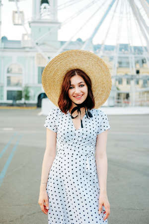 Cute caucasian brunette in white dress walking alone in the streets in downtownの写真素材