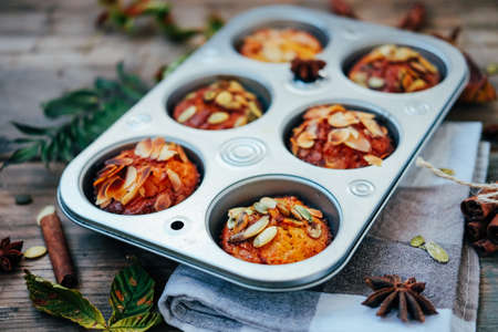 Healthy fall vegetarian dessert. Apple cupcake with pumpkin, almond seeds and spices.の写真素材