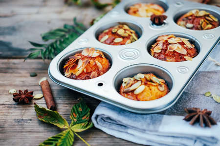 Healthy fall vegetarian dessert. Apple cupcake with pumpkin, almond seeds and spices.の写真素材
