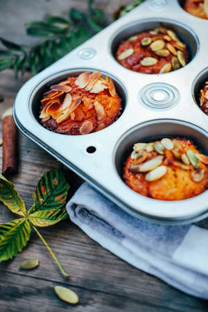 Healthy fall vegetarian dessert. Apple cupcake with pumpkin, almond seeds and spices.の写真素材
