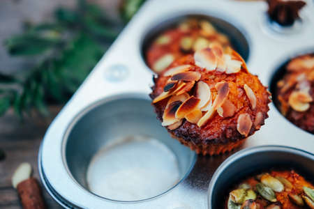 Healthy fall vegetarian dessert. Apple cupcake with pumpkin, almond seeds and spices.の写真素材