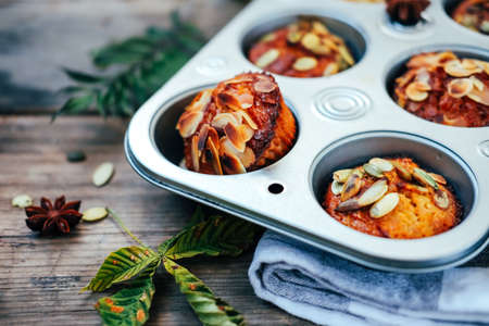 Healthy fall vegetarian dessert. Apple cupcake with pumpkin, almond seeds and spices.の写真素材