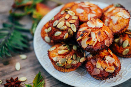 Healthy fall vegetarian dessert. Apple cupcake with pumpkin, almond seeds and spices.の写真素材