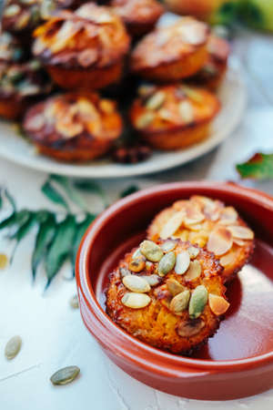 Healthy fall vegetarian dessert. Apple cupcake with pumpkin, almond seeds and spices.の写真素材