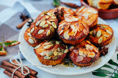 Healthy fall vegetarian dessert. Apple cupcake with pumpkin, almond seeds and spices.の写真素材