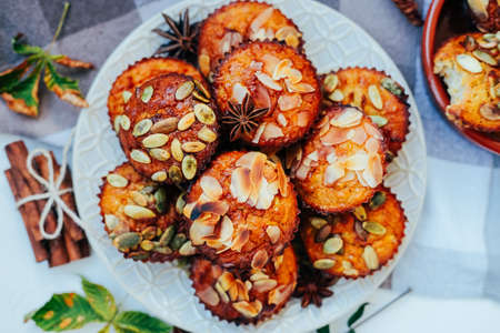 Healthy fall vegetarian dessert. Apple cupcake with pumpkin, almond seeds and spices.の写真素材