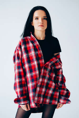Young adult woman posing. Casual outfit. Woman wearing lumberjack shirt.の写真素材