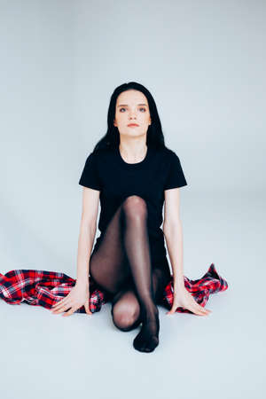 Young adult woman posing. Casual outfit. Woman wearing lumberjack shirt.