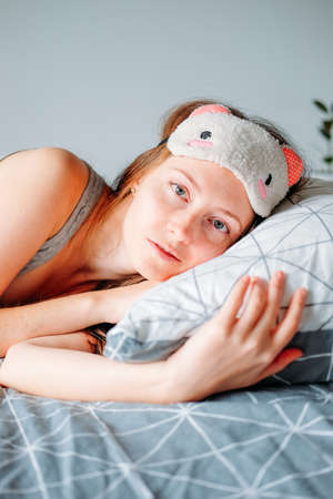 Woman with long hair in her bedroom sleeping on cozy soft pillow