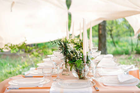 Festive table setting for the wedding venue. Peach summer decoration.の写真素材