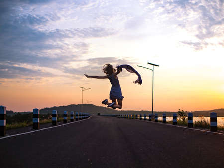 happy woman jumping on the roadの写真素材