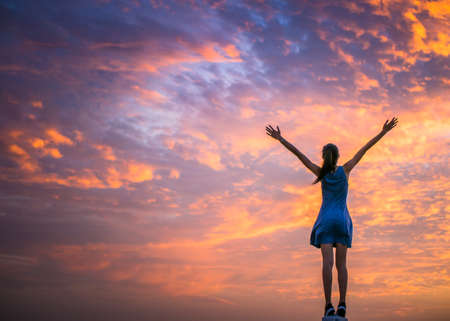 woman standing with beautiful cloudの写真素材