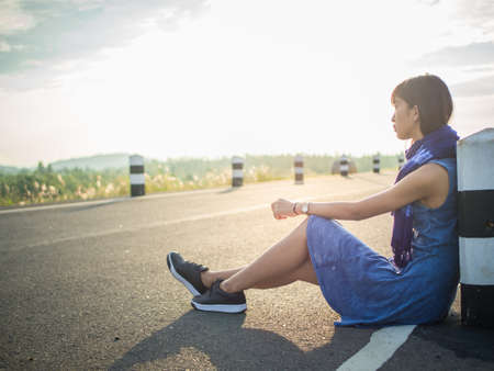 woman sitting alone on the roadの写真素材