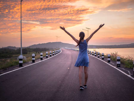 relax woman walking on the road with beautiful skyの写真素材