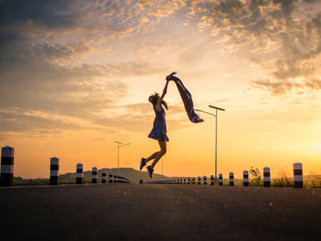 happy woman jumping on the roadの写真素材