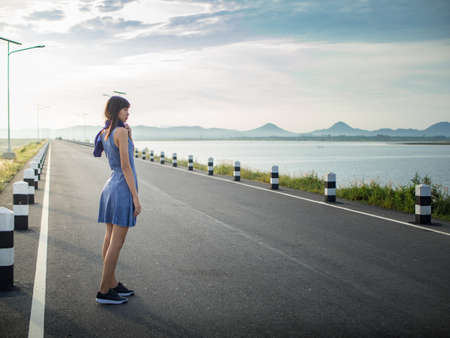 Happy young woman walking on the roadの写真素材