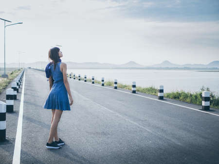 Happy young woman walking on the roadの写真素材