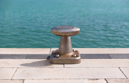 A bollard with a blue sicilian sea behindの写真素材