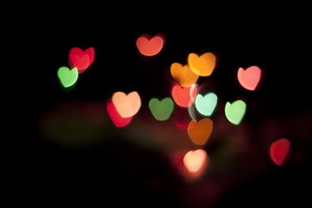 defocused colors hearts background on blackの写真素材