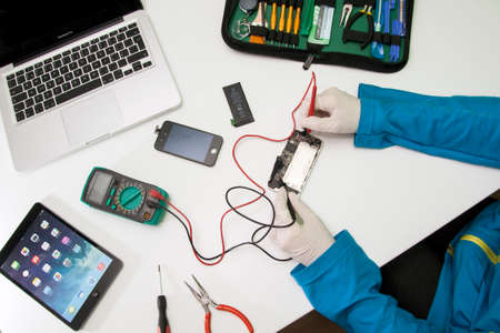 Prague, Czech Republic - NOVEMBER 30, 2014: Photo of the repair process of an iPhone 4. IPhone 4 are produced by Apple Computer, Inc..のeditorial素材