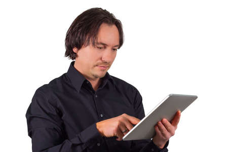 Attractive man standing browsing on a tablet computer using his finger to scroll or type on the touchscreen , head and shoulders portrait isolated on whiteの写真素材