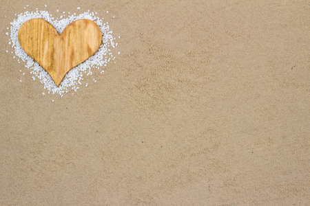 Handmade wood heart in the sand with copy space の写真素材