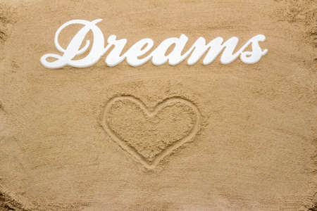 The sandy beach is the writing Dreams from wood  Including a heart drawn in the sand の写真素材