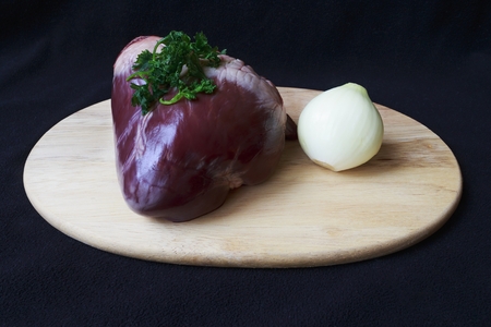 raw pork heart on boardの写真素材