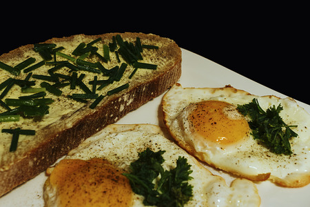 fried eggs with bread and butter on a white plate detailの写真素材