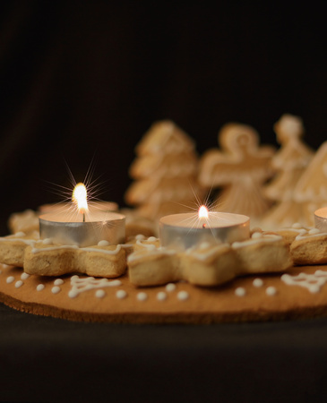 gingerbread wreath and lit candles on a dark background vertical viewの写真素材