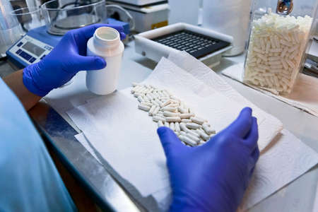 Packing white capsules in a boat in a pharmaceutical laboratory, Spainの写真素材