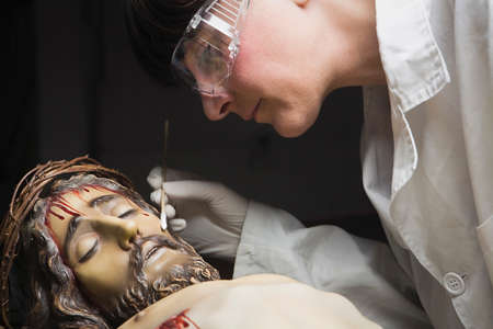 Cleaning of the face of a wooden sculpture of Christ crucified with an isopo impregnated with dimethylformamide, Andalusia, Spainの写真素材