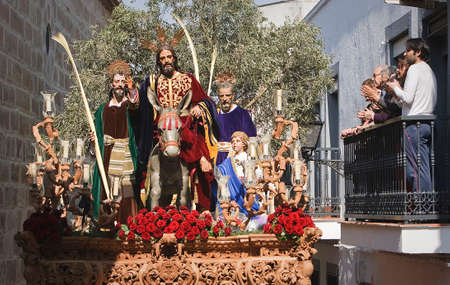 Family on a balcony watching the throne of the brotherhood of the entry in Jerusalem, Linares, Jan province, Spainのeditorial素材