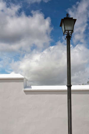 A wrought iron lamp on a weathered wall in Spain