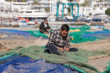 Sailor fixed their fishing nets in the port of Estepona, province of malaga, Spain