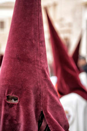 Detail penitent with red caperuz in Holy Week, Spain