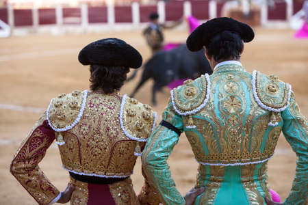  Ubeda, Jaen province, SPAIN - 29 september 2010  Spanish Bullfighters looking bullfighting, the Bullfighter on the left dressed in suit of lights of colors red and gold and the right color pistachio and gold in Ubeda, Jaen provincia, Andalusia, Spainのeditorial素材